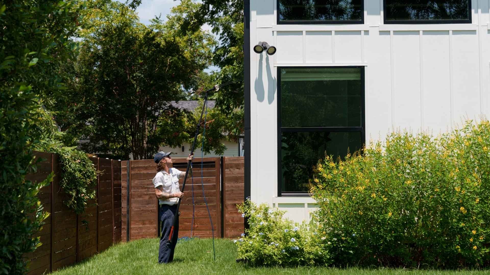 A Pink&rsquo;s technician cleaning windows at a residential home.