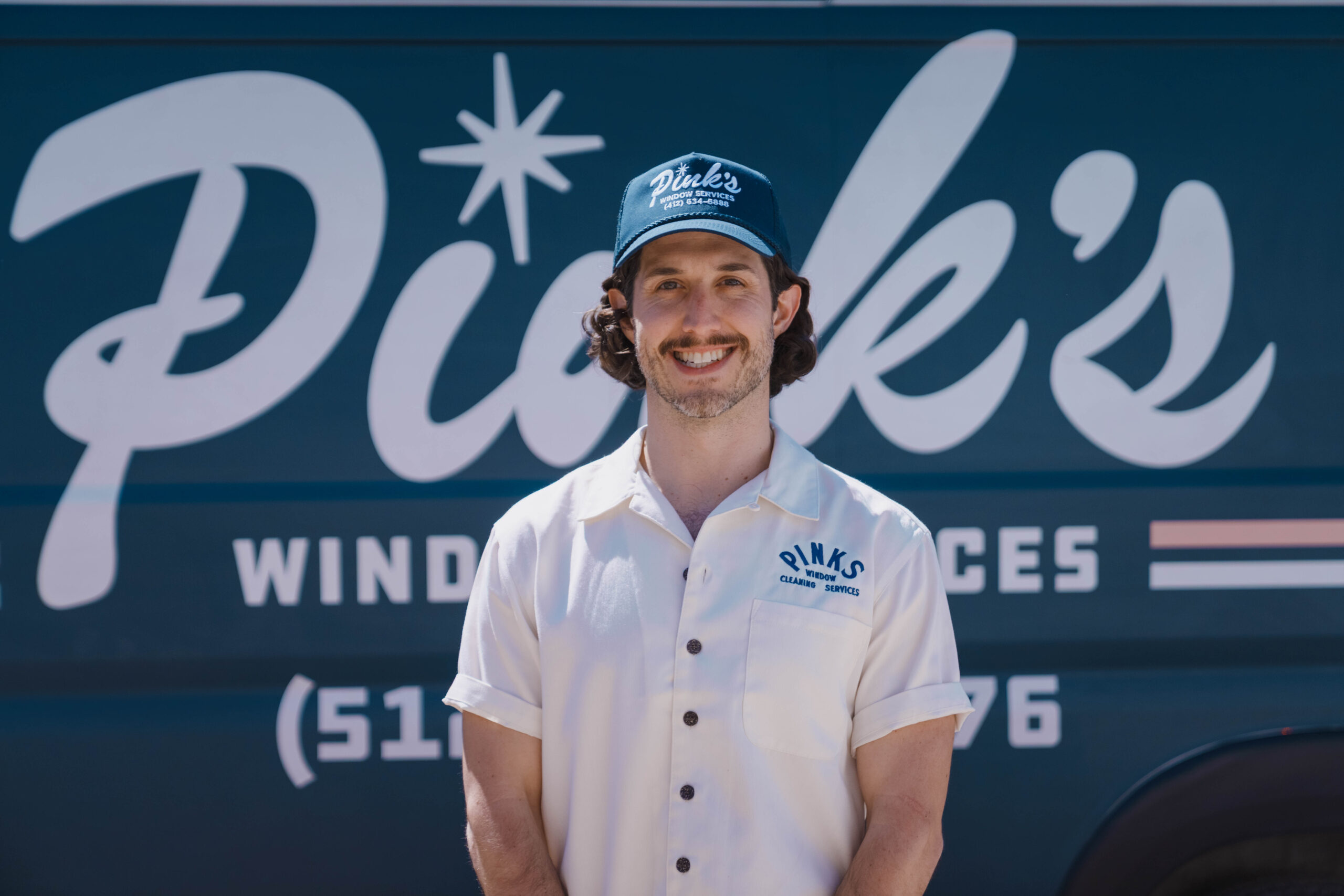 Pink's Windows Owner standing in front of his work van
